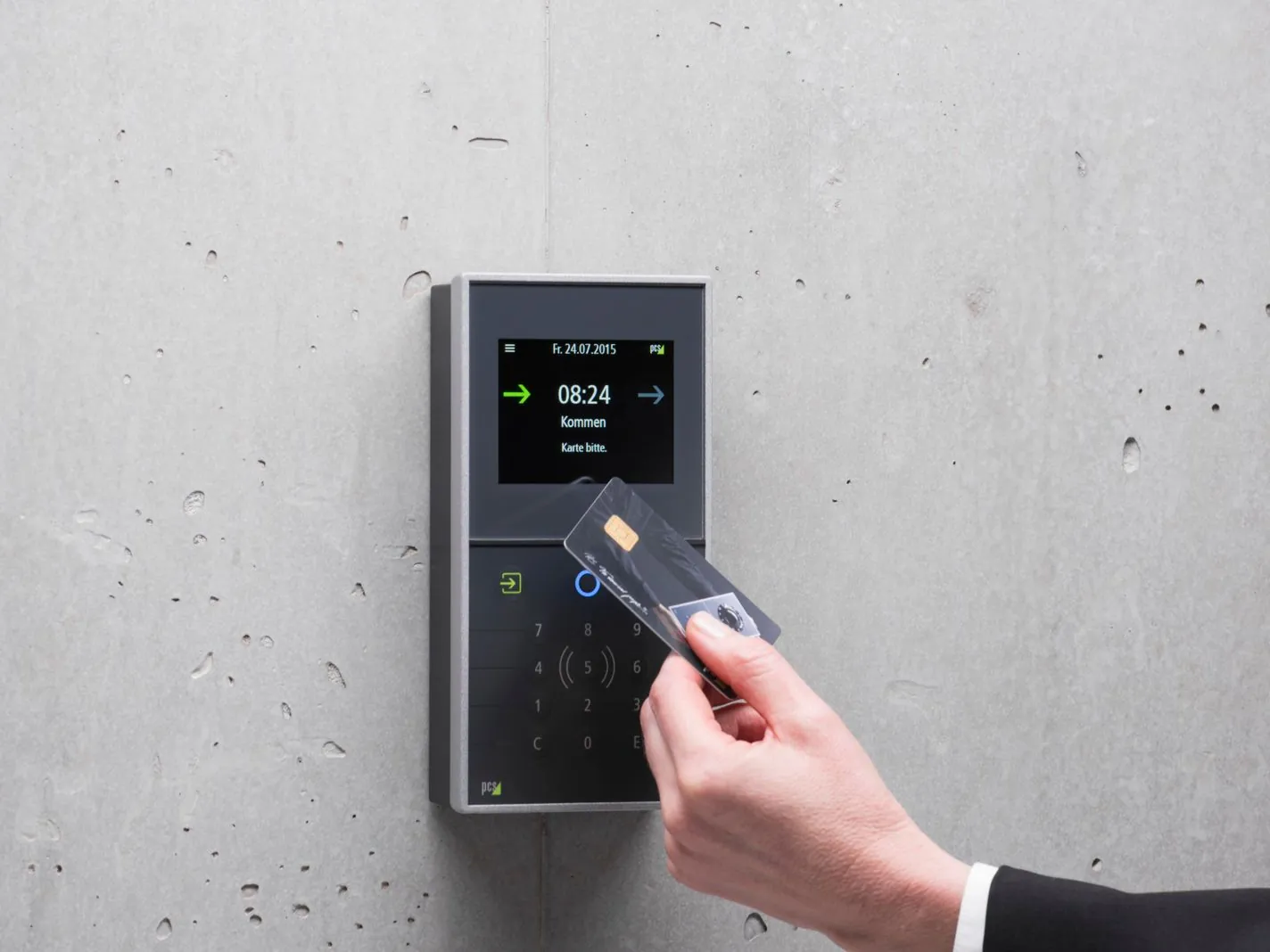 Mano acercando una tarjeta a un lector de control de acceso en la pared de una oficina