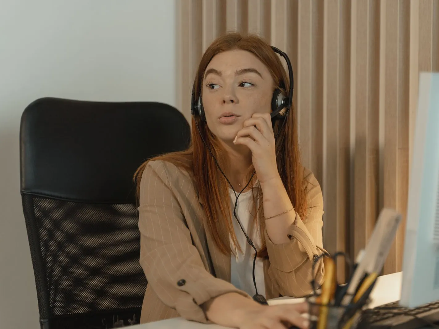 Recepcionista con diadema atendiendo una llamada en una oficina moderna